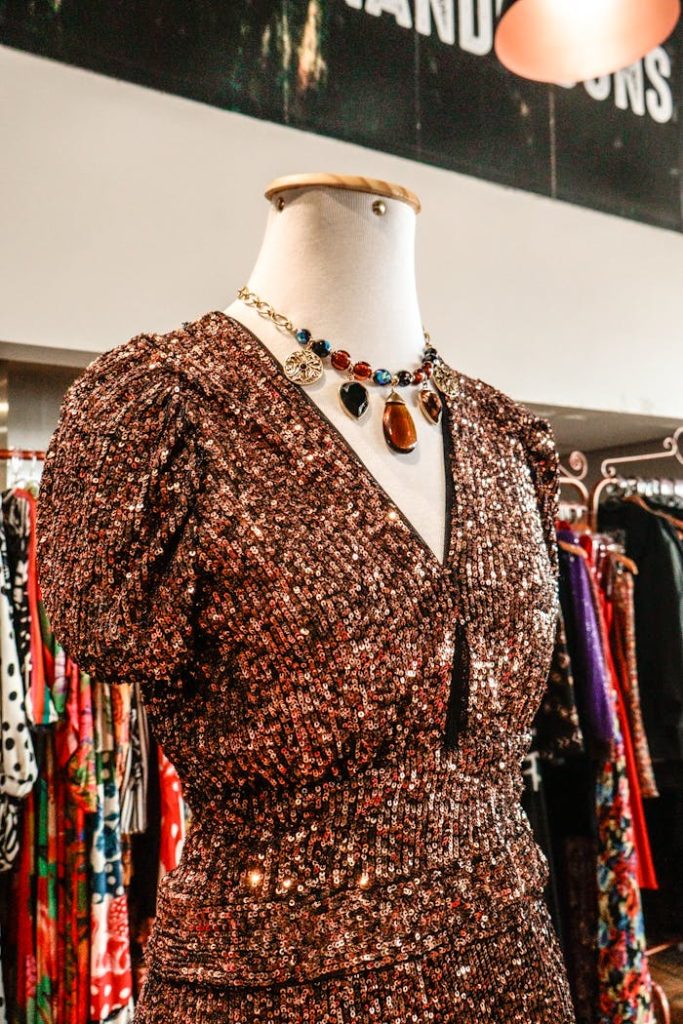 Chic sequined dress showcased on a mannequin in a fashion store. Perfect for glitzy occasions.