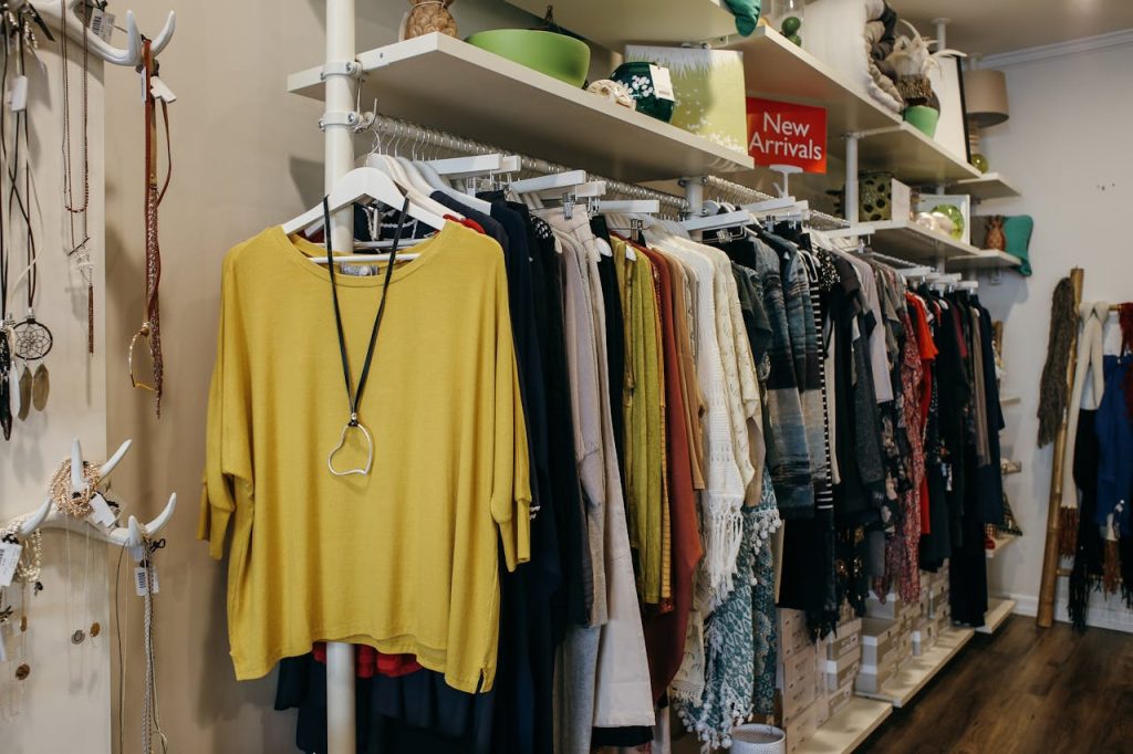 Interior of a fashion boutique with clothes elegantly displayed on racks and shelves.